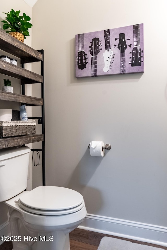 bathroom featuring baseboards, toilet, and wood finished floors