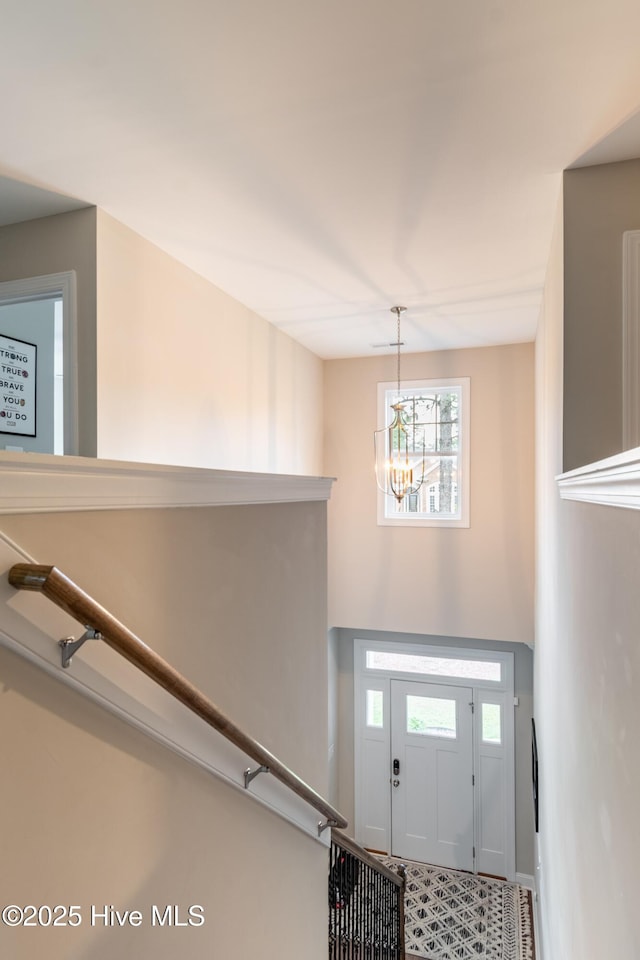 entrance foyer with a chandelier and baseboards