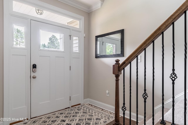entrance foyer with stairs, crown molding, and baseboards