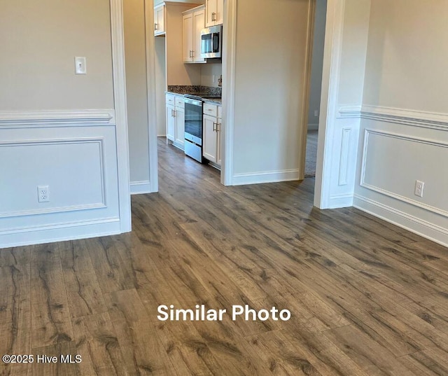 754 Secession Ln, Jacksonville, NC 28546 - kitchen featuring stainless steel appliances, dark wood-style floors, a decorative wall, white cabinets, and a wainscoted wall