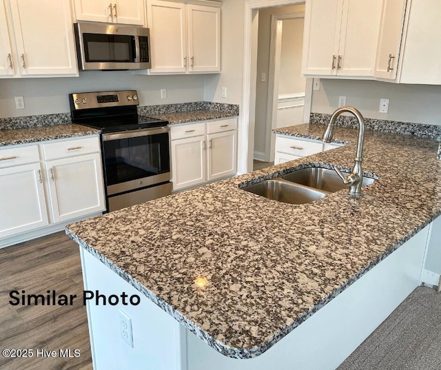 754 Secession Ln, Jacksonville, NC 28546 - kitchen featuring appliances with stainless steel finishes, a sink, white cabinets, and dark stone counters