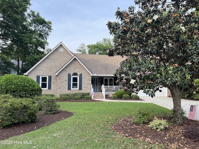 ranch-style house featuring covered porch, a front yard, brick siding, and a shingled roof