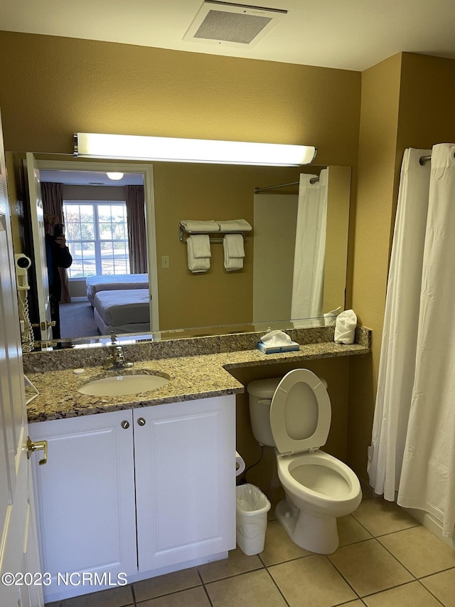 ensuite bathroom with tile patterned floors and vanity