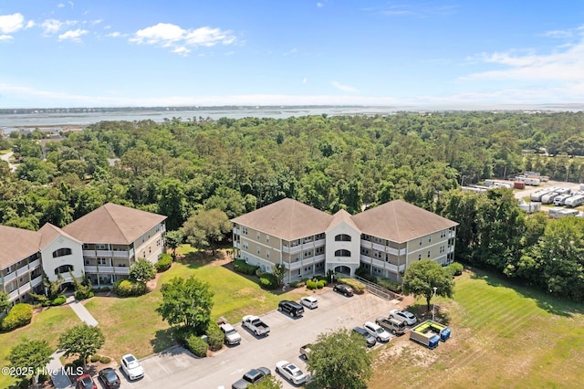 drone / aerial view of a large body of water and a heavily wooded area