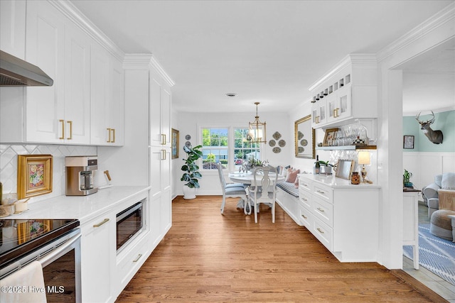 125 Windemere Rd, Wilmington, NC 28405 - kitchen with stainless steel appliances, light countertops, light wood-style flooring, white cabinetry, and a chandelier