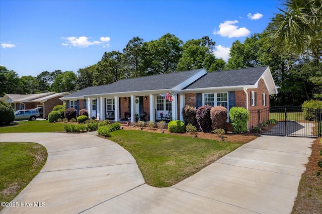 125 Windemere Rd, Wilmington, NC 28405 - single story home featuring brick siding, concrete driveway, a front yard, a porch, and roof with shingles