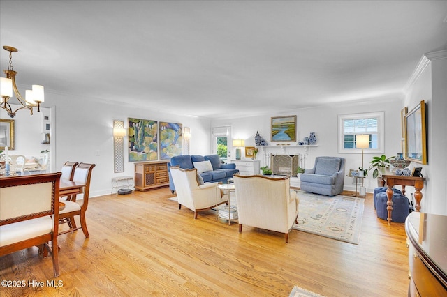 125 Windemere Rd, Wilmington, NC 28405 - living room featuring crown molding, a chandelier, light wood-style floors, plenty of natural light, and a fireplace