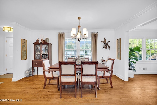 125 Windemere Rd, Wilmington, NC 28405 - dining area with a chandelier, light wood-type flooring, and crown molding