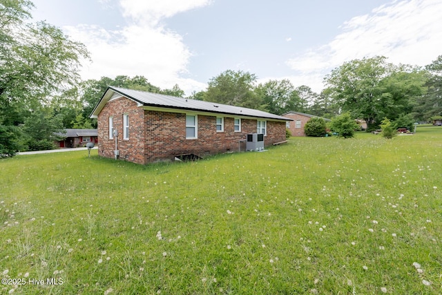 608 Richardson St, Elizabethtown, NC 28337 - view of home's exterior featuring a yard, brick siding, cooling unit, and metal roof