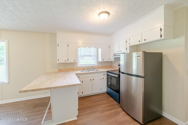 608 Richardson St, Elizabethtown, NC 28337 - kitchen featuring freestanding refrigerator, electric range oven, a peninsula, light wood-style floors, and a textured ceiling