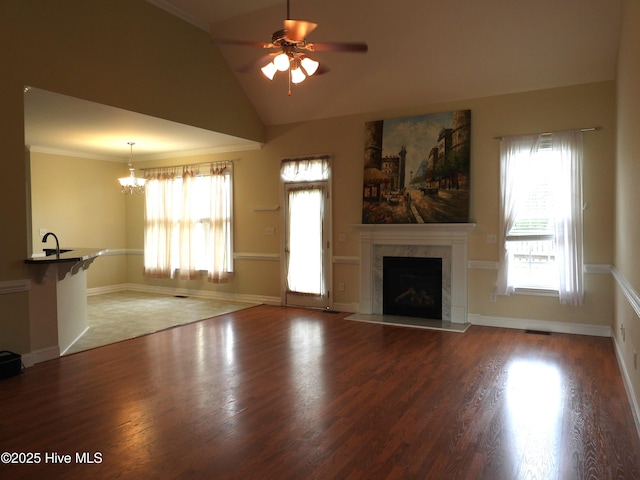644 Milton Dr, Winterville, NC 28590 - unfurnished living room with ceiling fan, healthy amount of natural light, wood finished floors, a high end fireplace, and vaulted ceiling