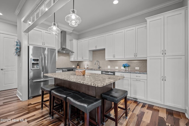 1218 Pinfish Ln, Carolina Beach, NC 28428 - kitchen featuring stainless steel appliances, wall chimney range hood, crown molding, a sink, and a breakfast bar