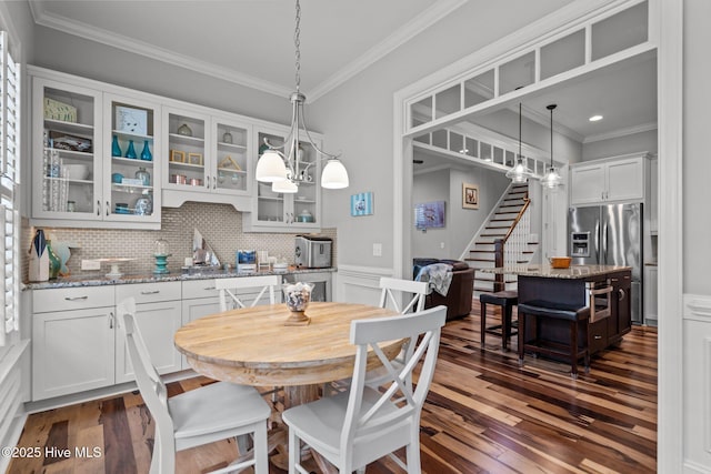 1218 Pinfish Ln, Carolina Beach, NC 28428 - dining area featuring stairs, ornamental molding, dark wood finished floors, and a wainscoted wall