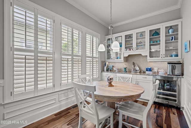 1218 Pinfish Ln, Carolina Beach, NC 28428 - dining room with beverage cooler, dark wood-style floors, and ornamental molding