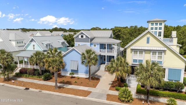1218 Pinfish Ln, Carolina Beach, NC 28428 - beach home featuring a balcony, metal roof, a residential view, a standing seam roof, and a porch
