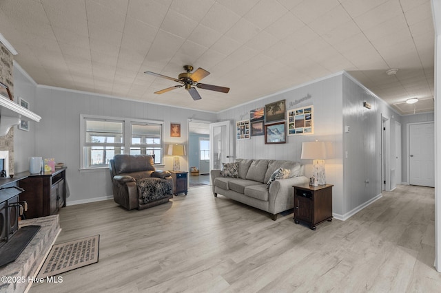 2285 Old Pamlico Beach Rd W, Belhaven, NC 27810 - living room with ornamental molding, ceiling fan, light wood-style flooring, a wood stove, and baseboards