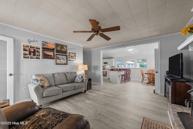 2285 Old Pamlico Beach Rd W, Belhaven, NC 27810 - living room featuring crown molding, ceiling fan, light wood-type flooring, baseboards, and wood walls