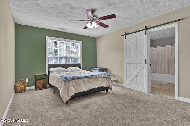 102 Rocky Ct, Richlands, NC 28574 - carpeted bedroom featuring a barn door, baseboards, ceiling fan, and a textured ceiling