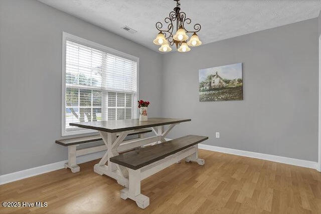 102 Rocky Ct, Richlands, NC 28574 - dining space featuring a chandelier, baseboards, light wood-style flooring, and a textured ceiling