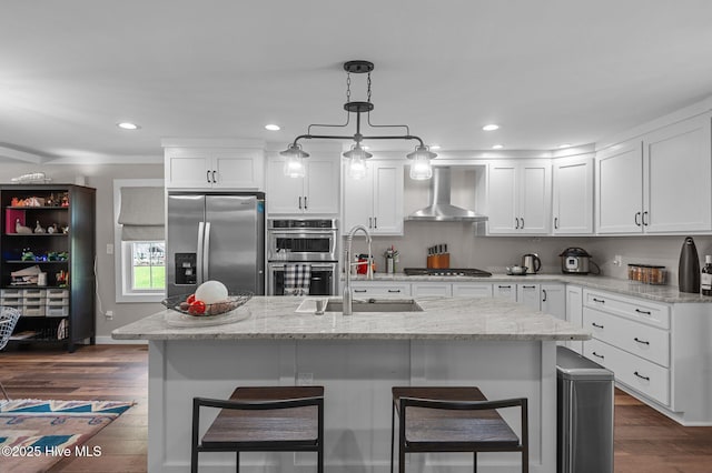 105 N Main St, Bath, NC 27808 - kitchen featuring wall chimney range hood, stainless steel appliances, a sink, a kitchen bar, and white cabinetry