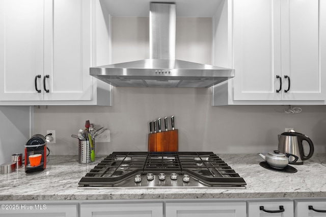 105 N Main St, Bath, NC 27808 - kitchen with wall chimney exhaust hood, stainless steel gas stovetop, white cabinets, and light stone countertops