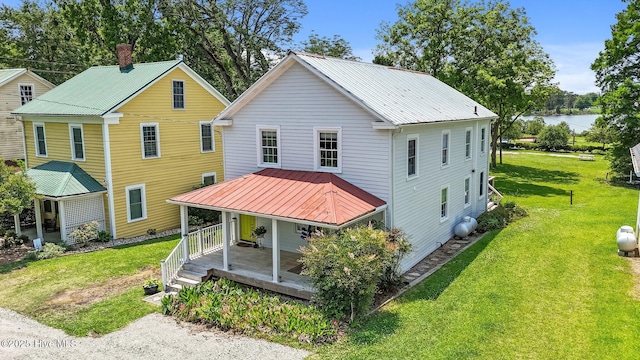105 N Main St, Bath, NC 27808 - view of front of property with a porch, a chimney, a front yard, and metal roof