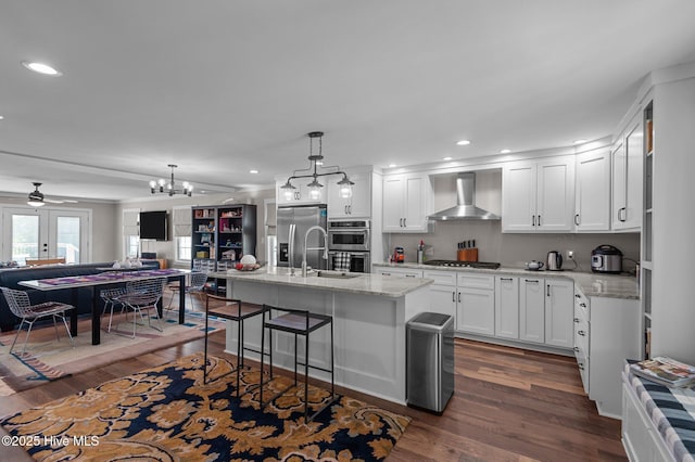 105 N Main St, Bath, NC 27808 - kitchen with wall chimney range hood, stainless steel appliances, open floor plan, dark wood-type flooring, and a chandelier