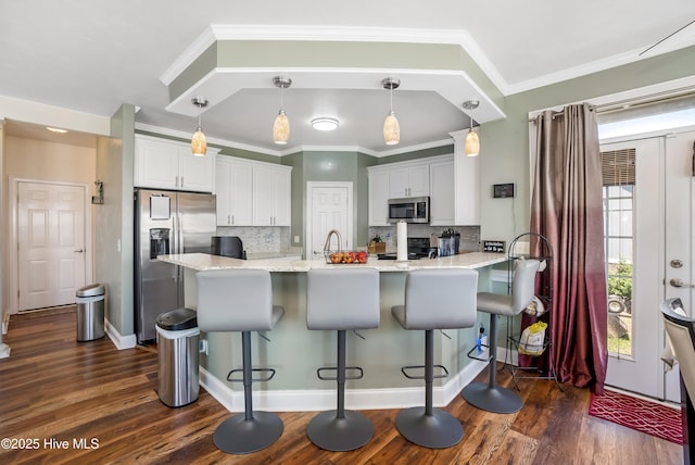 118 Durant St, Hertford, NC 27944 - kitchen featuring stainless steel appliances, a peninsula, dark wood finished floors, white cabinets, and tasteful backsplash