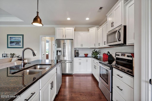 968 Woodwind Dr, Leland, NC 28451 - kitchen featuring appliances with stainless steel finishes, a sink, crown molding, recessed lighting, and dark stone countertops