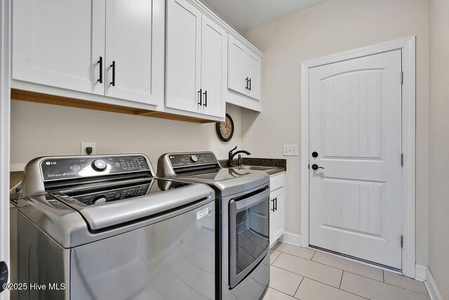 968 Woodwind Dr, Leland, NC 28451 - laundry area with independent washer and dryer, cabinet space, light tile patterned floors, and baseboards