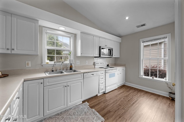 133 Moses Griffin Ln, New Bern, NC 28562 - kitchen with white appliances, a sink, vaulted ceiling, white cabinetry, and wood finished floors