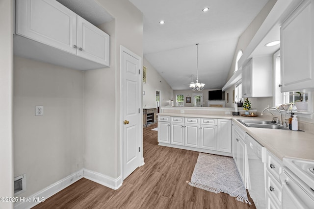 133 Moses Griffin Ln, New Bern, NC 28562 - kitchen with white dishwasher, a sink, light wood finished floors, a chandelier, and white cabinets