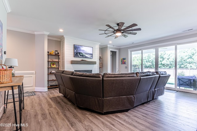 90 N Lamplighters Walk, Hampstead, NC 28443 - living area featuring a large fireplace, light wood finished floors, ceiling fan, recessed lighting, and ornamental molding