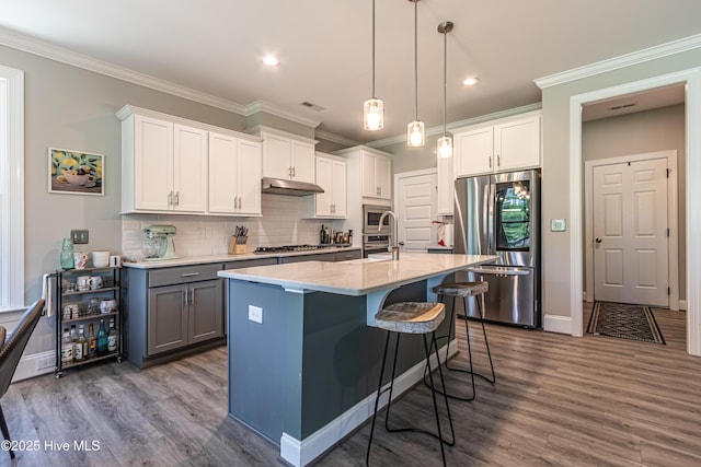 90 N Lamplighters Walk, Hampstead, NC 28443 - kitchen featuring appliances with stainless steel finishes, dark wood finished floors, a kitchen bar, backsplash, and decorative light fixtures