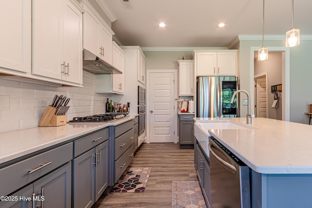 90 N Lamplighters Walk, Hampstead, NC 28443 - kitchen featuring under cabinet range hood, stainless steel appliances, crown molding, a sink, and backsplash
