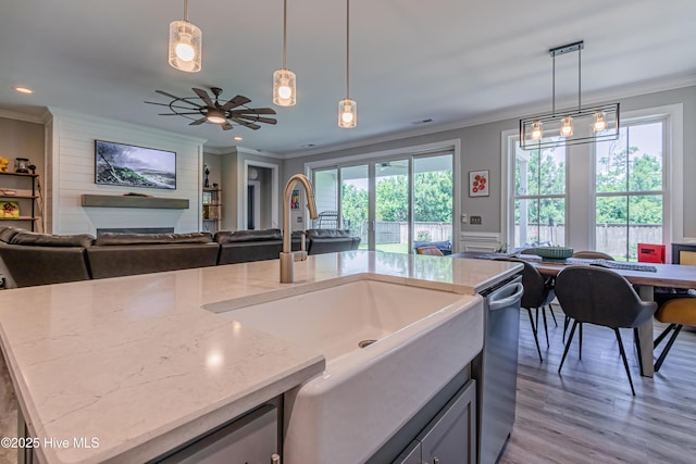 90 N Lamplighters Walk, Hampstead, NC 28443 - kitchen featuring open floor plan, a sink, light stone counters, crown molding, and light wood-style flooring