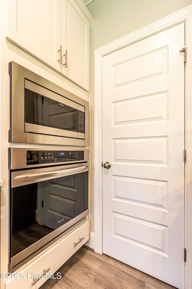 90 N Lamplighters Walk, Hampstead, NC 28443 - kitchen with stainless steel appliances, light wood-type flooring, and white cabinetry
