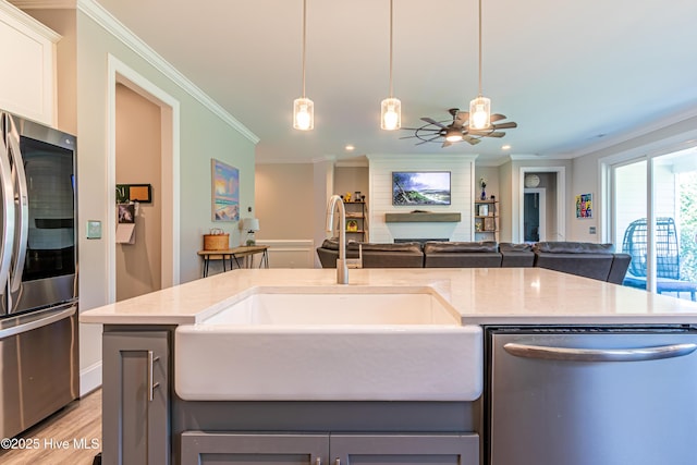 90 N Lamplighters Walk, Hampstead, NC 28443 - kitchen featuring appliances with stainless steel finishes, crown molding, a ceiling fan, a sink, and light stone counters