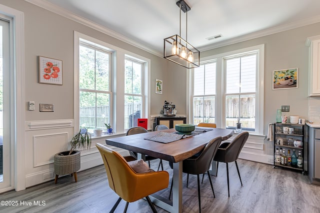 90 N Lamplighters Walk, Hampstead, NC 28443 - dining area with plenty of natural light, ornamental molding, light wood-style flooring, wainscoting, and a decorative wall