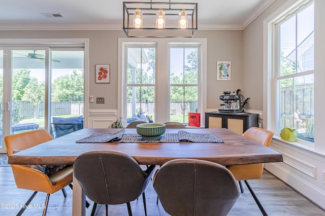 90 N Lamplighters Walk, Hampstead, NC 28443 - dining room with healthy amount of natural light, a decorative wall, crown molding, wood finished floors, and a wainscoted wall