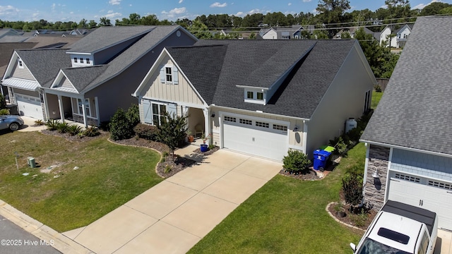 90 N Lamplighters Walk, Hampstead, NC 28443 - view of front of house featuring board and batten siding, concrete driveway, roof with shingles, and a front lawn