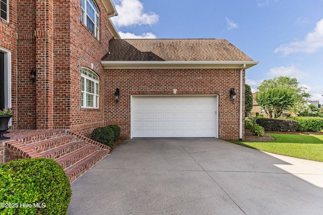 6575 Longwater Ct SW, Ocean Isle Beach, NC 28469 - view of home's exterior with driveway, a shingled roof, brick siding, and an attached garage