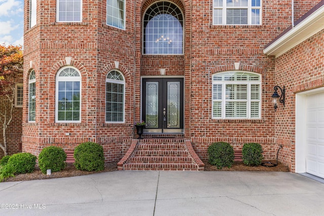 6575 Longwater Ct SW, Ocean Isle Beach, NC 28469 - property entrance featuring french doors, brick siding, and driveway