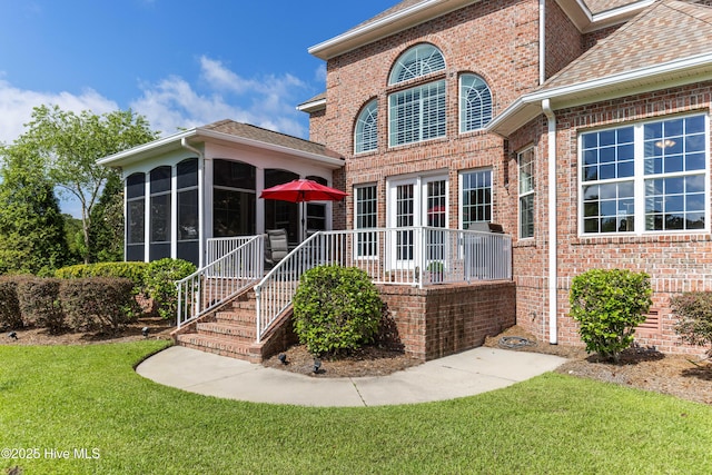 6575 Longwater Ct SW, Ocean Isle Beach, NC 28469 - back of property with a yard, a sunroom, brick siding, and a shingled roof