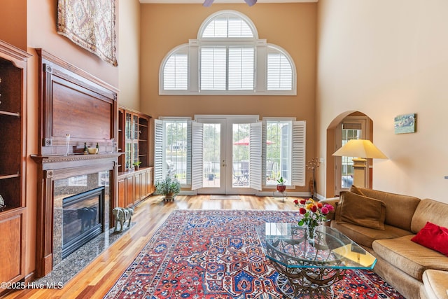 6575 Longwater Ct SW, Ocean Isle Beach, NC 28469 - living area with a premium fireplace, a high ceiling, wood finished floors, french doors, and a ceiling fan