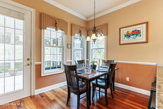 6575 Longwater Ct SW, Ocean Isle Beach, NC 28469 - dining room featuring a chandelier, wood finished floors, crown molding, and baseboards