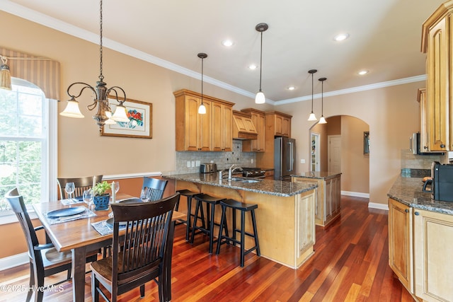 6575 Longwater Ct SW, Ocean Isle Beach, NC 28469 - kitchen featuring arched walkways, high quality fridge, premium range hood, a peninsula, and backsplash