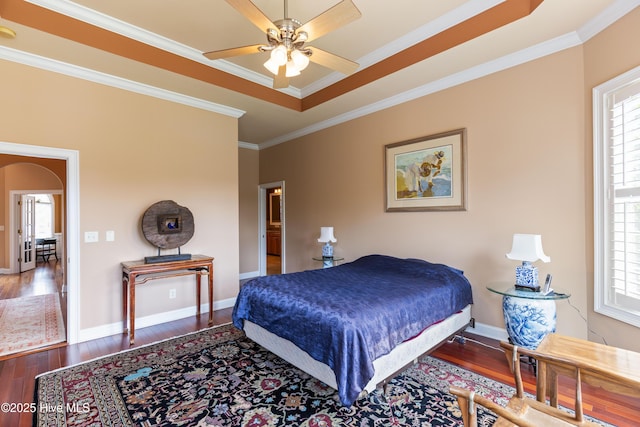 6575 Longwater Ct SW, Ocean Isle Beach, NC 28469 - bedroom featuring wood finished floors, multiple windows, arched walkways, crown molding, and baseboards