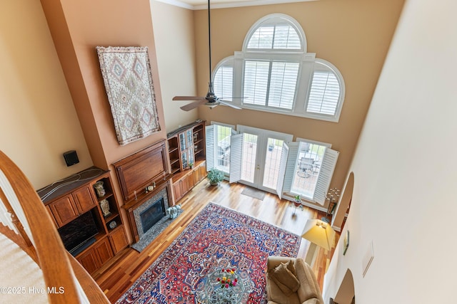 6575 Longwater Ct SW, Ocean Isle Beach, NC 28469 - living area with a high ceiling, french doors, light wood-style floors, a ceiling fan, and a fireplace