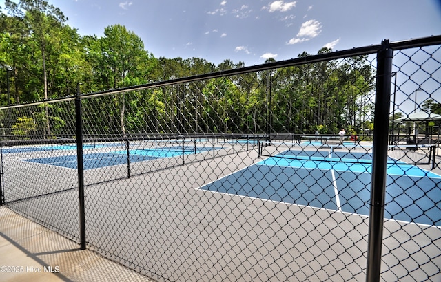 6575 Longwater Ct SW, Ocean Isle Beach, NC 28469 - view of pool with a tennis court, fence, and view of scattered trees